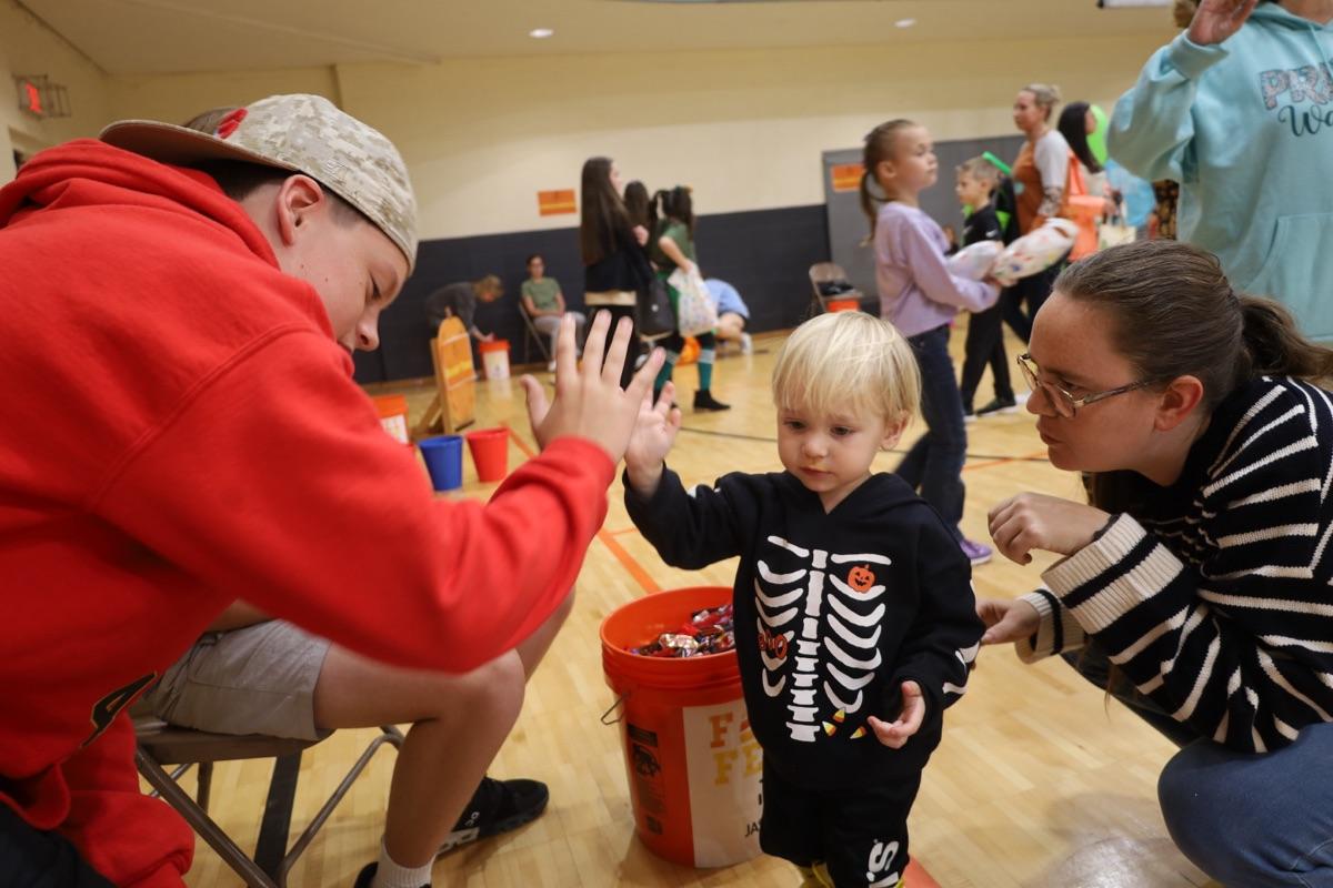 Volunteer high-fiving a child in costume